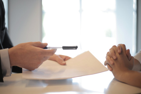 two people signing a document